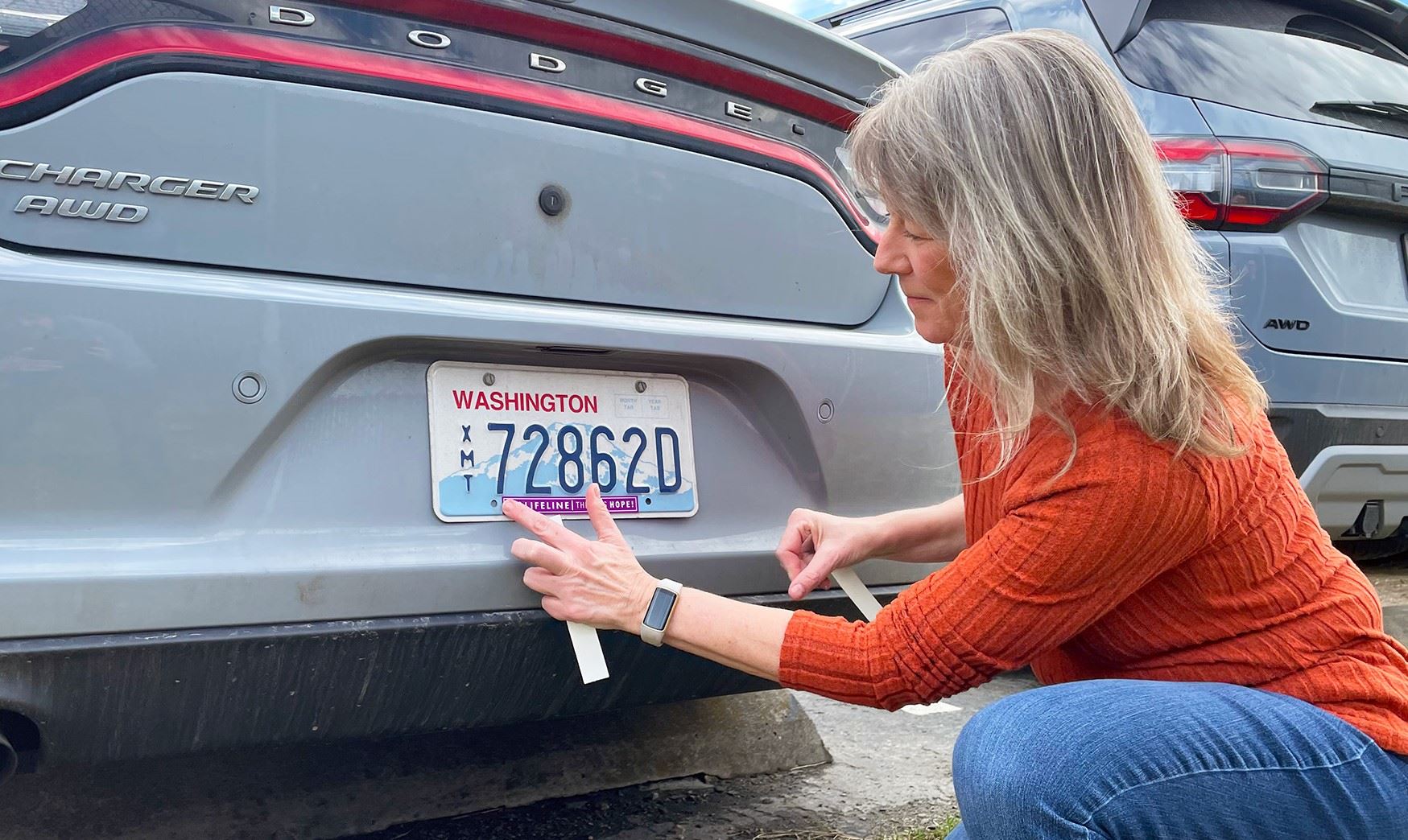 Mayor Kaminskas adding sticker to license plate - 3-2025
